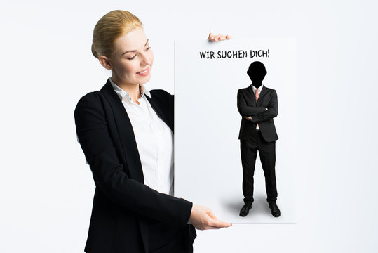 businesswoman holding sign with German message "We are looking for you"