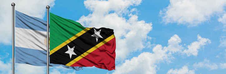 Argentina and Saint Kitts And Nevis flag waving in the wind against white cloudy blue sky together. Diplomacy concept, international relations.