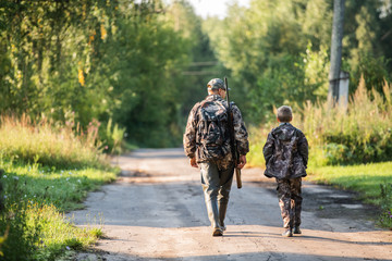 father pointing and guiding son on first deer hunt - 297435422