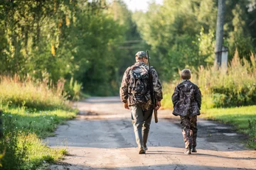 Foto op Plexiglas vader wijst en begeleidt zoon op eerste hertenjacht © romankosolapov