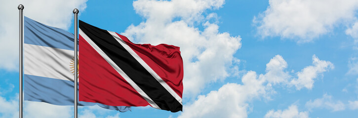 Argentina and Trinidad And Tobago flag waving in the wind against white cloudy blue sky together. Diplomacy concept, international relations.