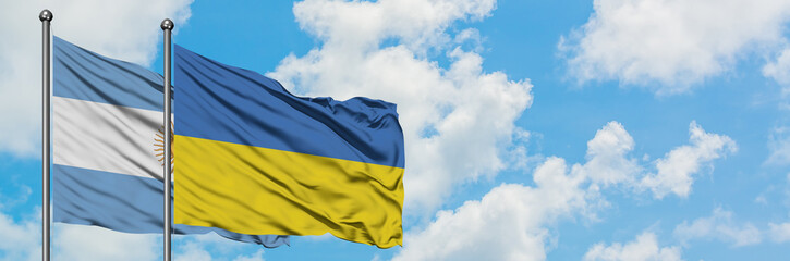 Argentina and Ukraine flag waving in the wind against white cloudy blue sky together. Diplomacy concept, international relations.
