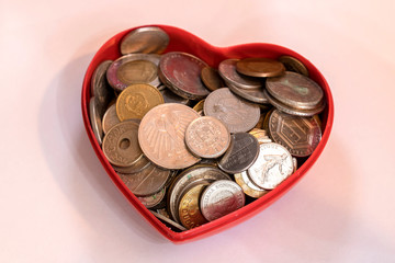 Old coins background in a Heart shaped container