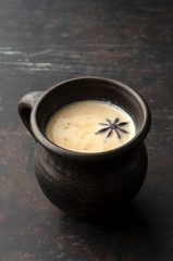 Traditional indian tea masala on dark background in clay cup