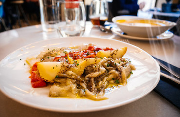 Close-up view of traditional Catalan cuisine dish in cafe restaurant bar - potatoes and chicken meat with pepper vegetables
