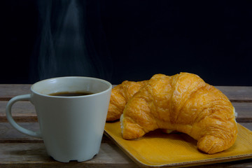 Hot steam  Coffee with Croissant for a meal with black background