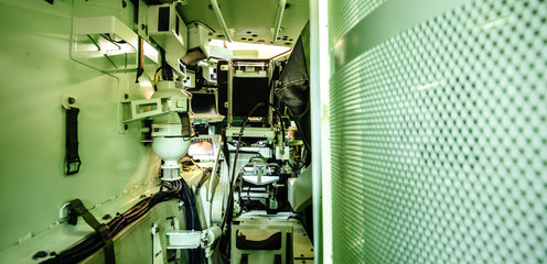 Interior view of empty multi-role armored military vehicle personnel carrier interior with diverse military equipments for infantry soldiers inside reconnaissance vehicle