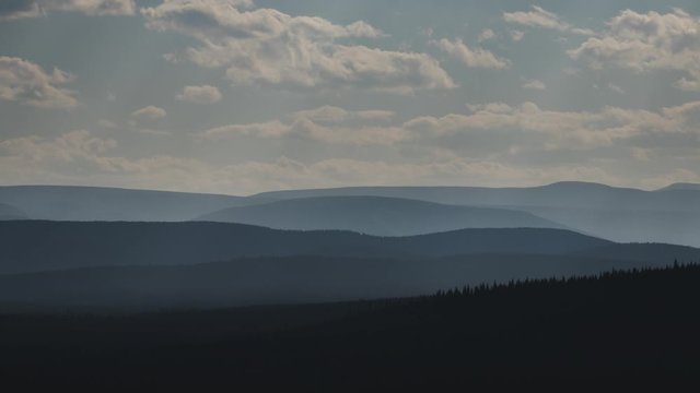 Smoke filled valley with silhouetted hills 4K time lapse