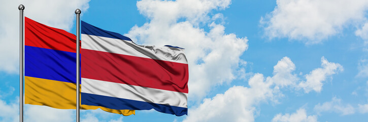Armenia and Costa Rica flag waving in the wind against white cloudy blue sky together. Diplomacy concept, international relations.