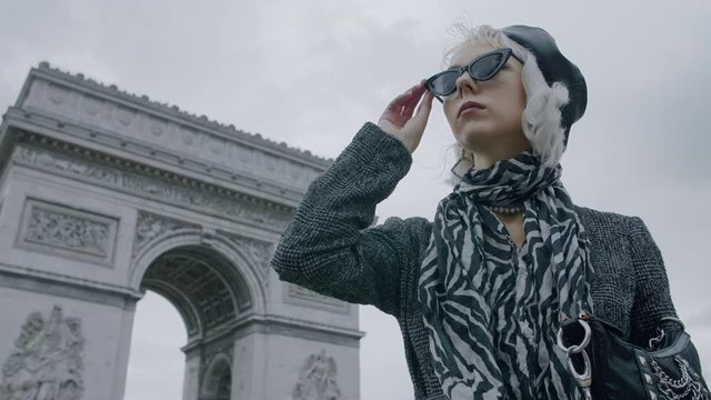 Outdoor autumn fashion portrait of elegant, luxury lady wearing trendy black boucle blazer, sunglasses, zebra print silk scarf, posing near Triumphal Arch in Paris
