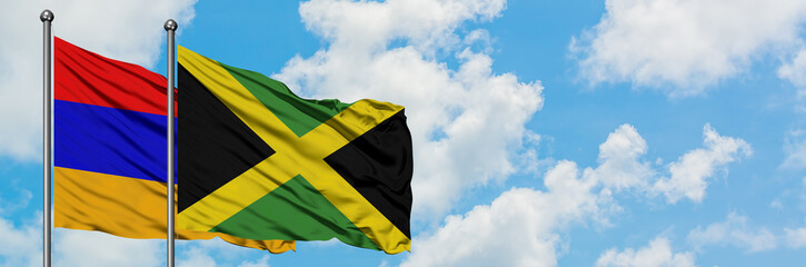 Armenia and Jamaica flag waving in the wind against white cloudy blue sky together. Diplomacy concept, international relations.
