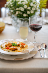 Typical dish of Ecuadorian food, soup based on cod fish, with milk and many grains, served with fried plantain, fried wheat dough and hard-boiled egg