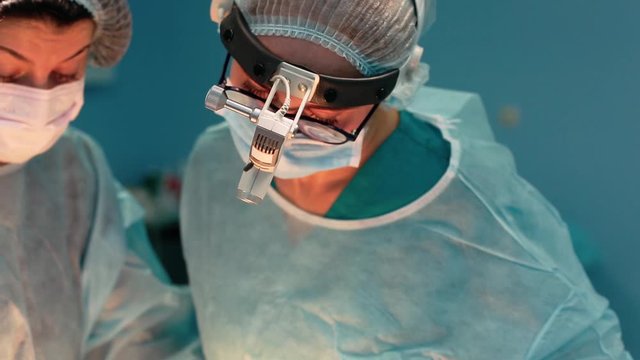 A team of surgeons has a major plan during surgery, a blue light operating room, a rhinoplasty operation to improve the aesthetics of the nose. Medetsina, plastic surgery.