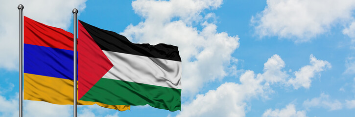 Armenia and Palestine flag waving in the wind against white cloudy blue sky together. Diplomacy...