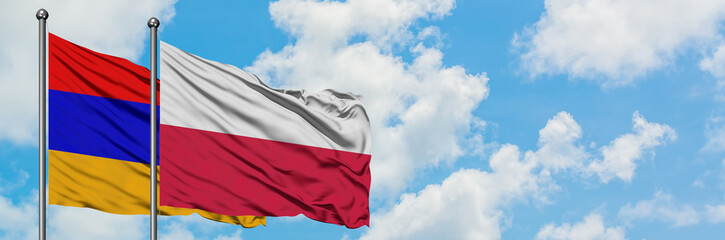 Armenia and Poland flag waving in the wind against white cloudy blue sky together. Diplomacy concept, international relations.