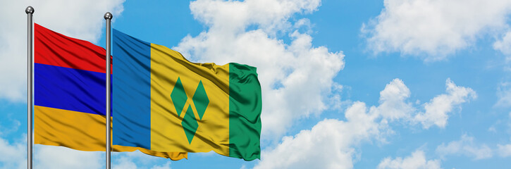 Armenia and Saint Vincent And The Grenadines flag waving in the wind against white cloudy blue sky together. Diplomacy concept, international relations.
