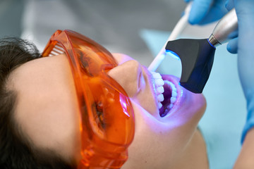 Pretty woman's teeth treatment in dental clinic