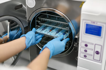 Dentist is loading dental probes into sterilize machine