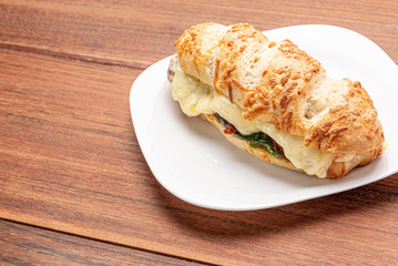 Beef steak sandwich with cheese and tomato, isolated on wooden background