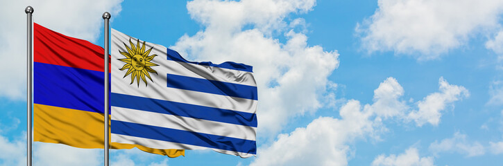 Fototapeta premium Armenia and Uruguay flag waving in the wind against white cloudy blue sky together. Diplomacy concept, international relations.
