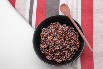 Cooked Sorghum (also known as sorgo) in a back bowl, isolated