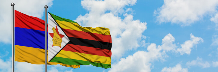 Armenia and Zimbabwe flag waving in the wind against white cloudy blue sky together. Diplomacy concept, international relations.