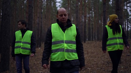 group of volunteers in green vests went in search of missing persons in a pine forest