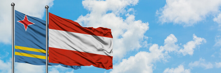Aruba and Austria flag waving in the wind against white cloudy blue sky together. Diplomacy concept, international relations.