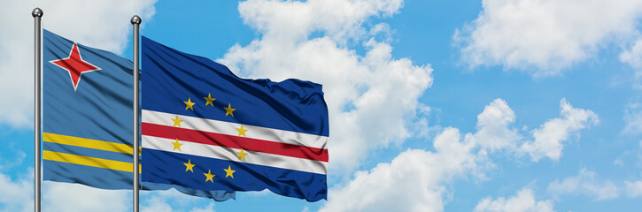 Aruba and Cape Verde flag waving in the wind against white cloudy blue sky together. Diplomacy concept, international relations.