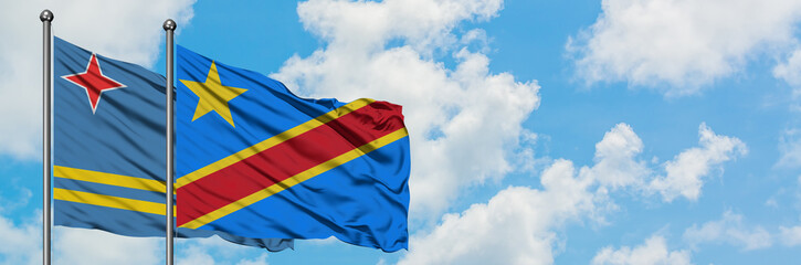 Aruba and Congo flag waving in the wind against white cloudy blue sky together. Diplomacy concept, international relations.