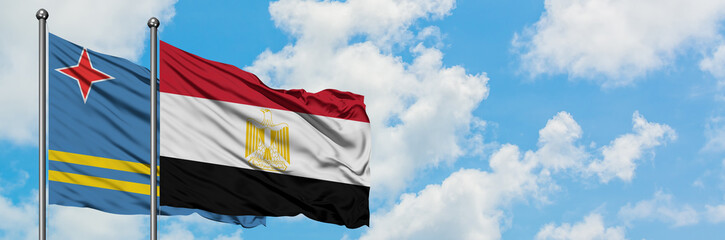 Aruba and Egypt flag waving in the wind against white cloudy blue sky together. Diplomacy concept, international relations.