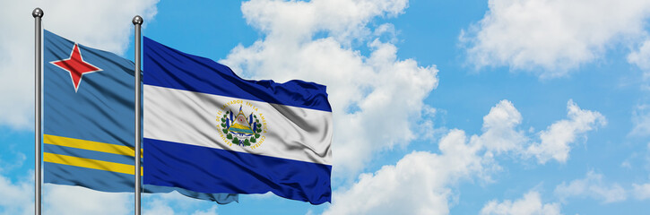 Aruba and El Salvador flag waving in the wind against white cloudy blue sky together. Diplomacy concept, international relations.