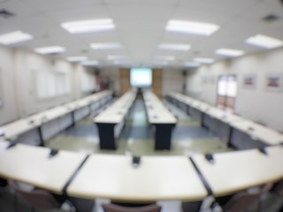 blurred image of empty auditorium room, interior of conference hall, seminar room with row of chair and table, Abstract blur for background usage.
