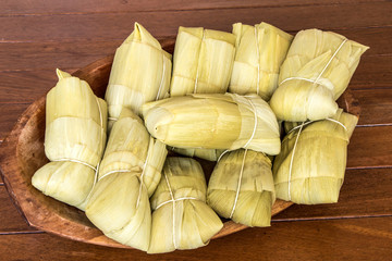 Pamonha. Brazilian Corn Snack on wooden basket in Brazil