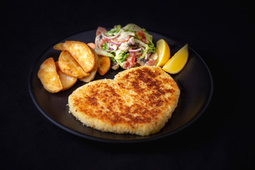 Heart shape Chicken Schnitzel with salad, fried potato wedges