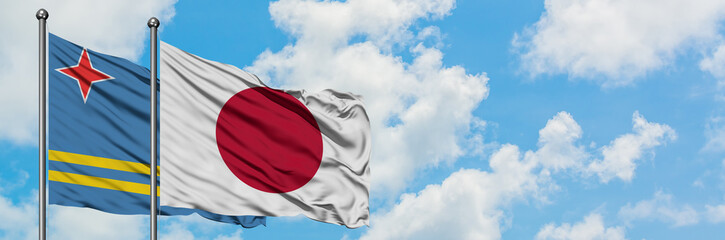Aruba and Japan flag waving in the wind against white cloudy blue sky together. Diplomacy concept, international relations.