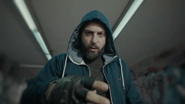 An eccentric controversial energetic  male urban rapper.Portrait and various performance shots of him performing in an underground city passage.