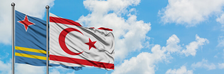 Aruba and Northern Cyprus flag waving in the wind against white cloudy blue sky together. Diplomacy concept, international relations.