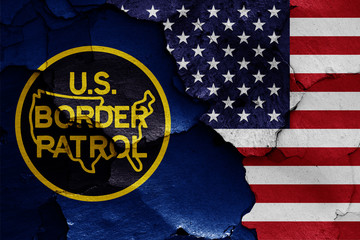 flags of United States Border Patrol and USA painted on cracked wall