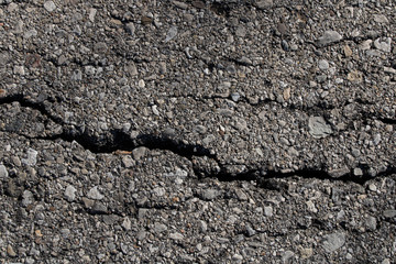 Cracked asphalt background.Black textured view.Road construction materials.Urban style.Black stones.