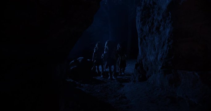 Portrait cavemen neanderthals wearing animal skin come into the cave at dark night stand near fire stone fun ancient history portrait evolution homo sapiens primitive campfire slow motion