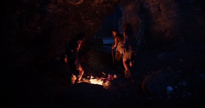 Shot of cavemen neanderthals wearing animal skin get out of the cave at dark night near fire stone fun ancient history portrait evolution homo sapiens primitive campfire slow motion