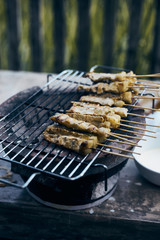 Pork satay grilling on stove.