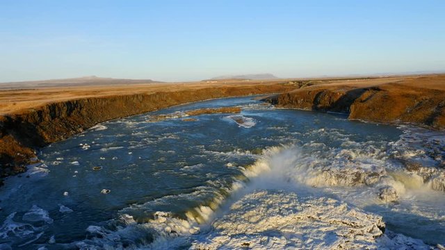 Aerial view of frozen Urriðafoss waterfall in Iceland with wild river