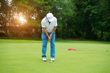 Blurred golfer playing golf in beautiful golf course in the evening golf course with sunshine in...