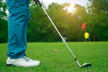 Blurred golfer playing golf in beautiful golf course in the evening golf course with sunshine in thailand