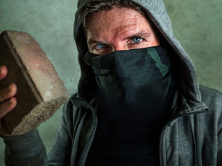 young man as fanatic and aggressive anarchist rioter . furious and scary violent anti-system...