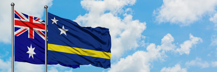 Australia and Curacao flag waving in the wind against white cloudy blue sky together. Diplomacy concept, international relations.