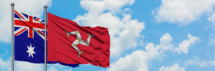 Australia and Isle Of Man flag waving in the wind against white cloudy blue sky together. Diplomacy...