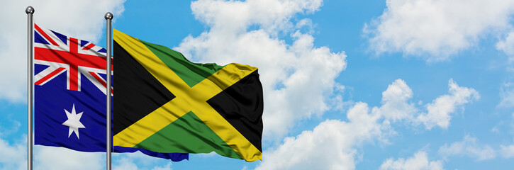 Australia and Jamaica flag waving in the wind against white cloudy blue sky together. Diplomacy concept, international relations.